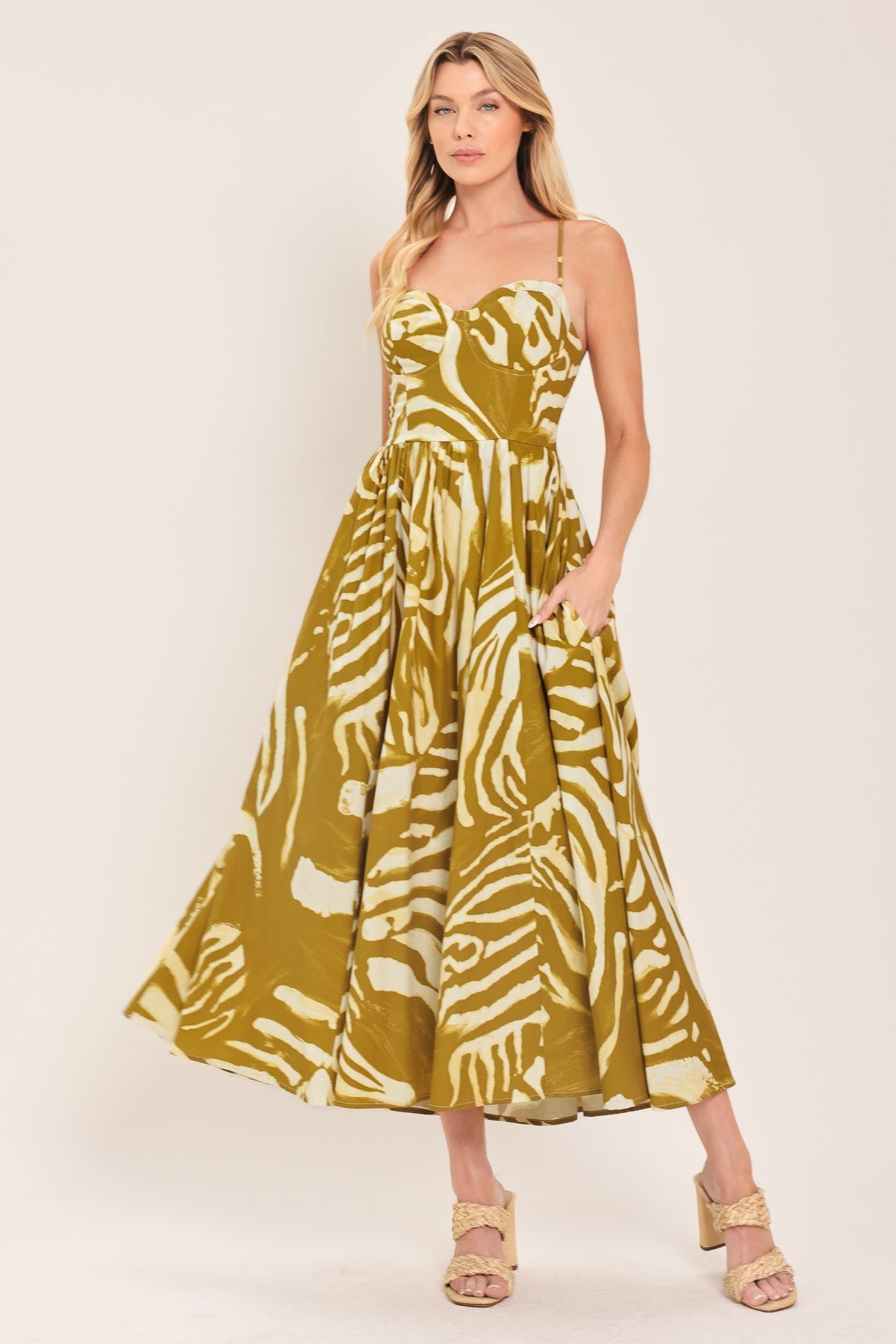 Woman wearing a mustard yellow and white patterned midi dress featuring bustier top, full skirt, bare back with lace up tie and zipper closure | Flying Tomato